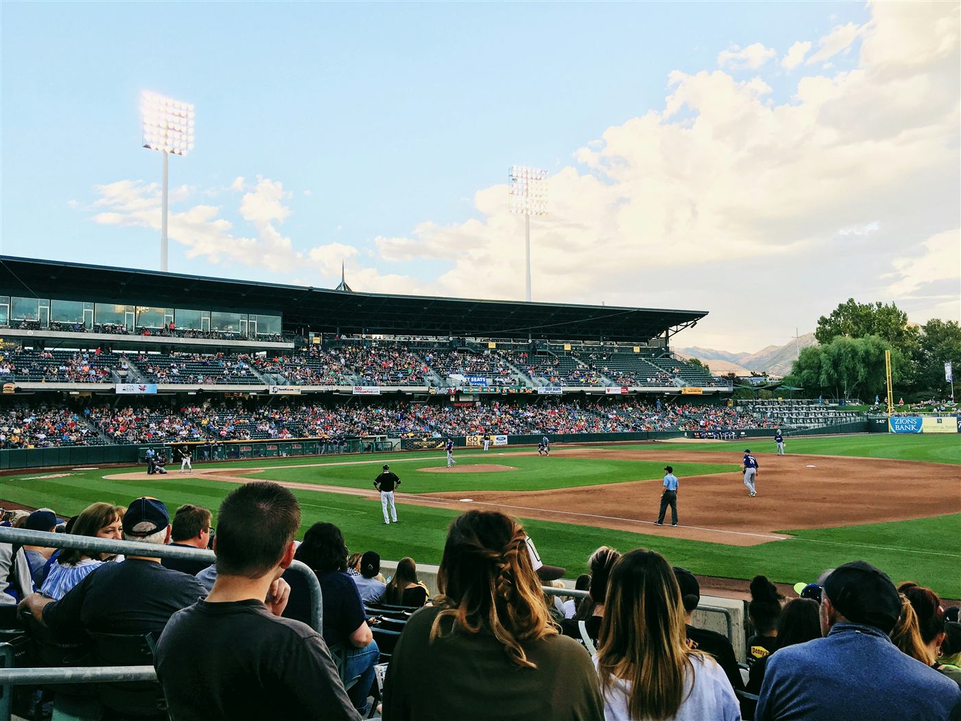 Fans watching a game at a sunny ballpark